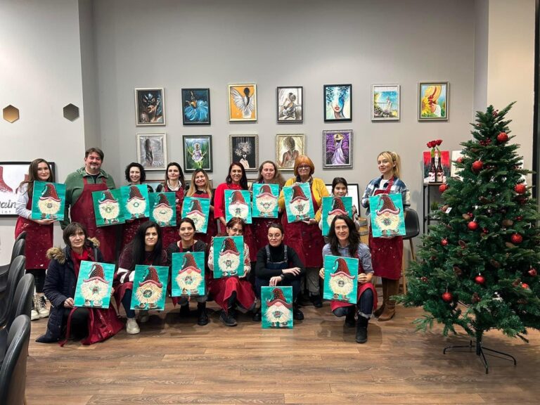 Група с коледни картини до елхата на фирмено коледно парти в Paint Me Sofia